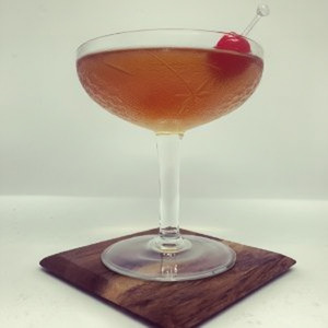 An image of the East India Cocktail cocktail submitted by Toby that contains Brandy, Raspberry Syrup, Angostura Bitters, Curaçao Triple Sec, Maraschino Liqueur and Cocktail Cherry