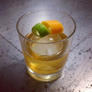An image of the Four Rum Old Fashioned cocktail submitted by Toby that contains Agricole Rhum, Arrack, Gold Rum, Cinnamon Syrup, Bob's Bitters Abbott's Bitter, Angostura Bitters, Lime and Orange